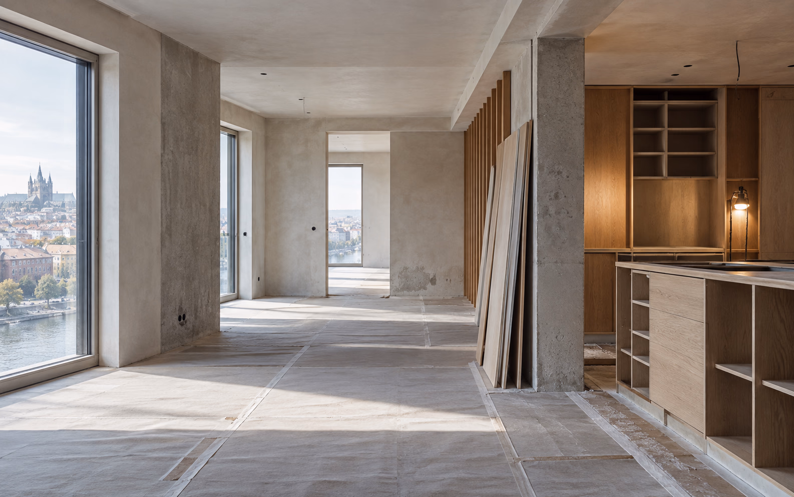 Contemporary interior part-way through renovation, with bare plaster walls, stacked oak boards and finished joinery along the far wall